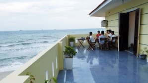 A group of people sitting at a table on a balcony overlooking the sea. - Mui Dinh Hotel (Ca Na)