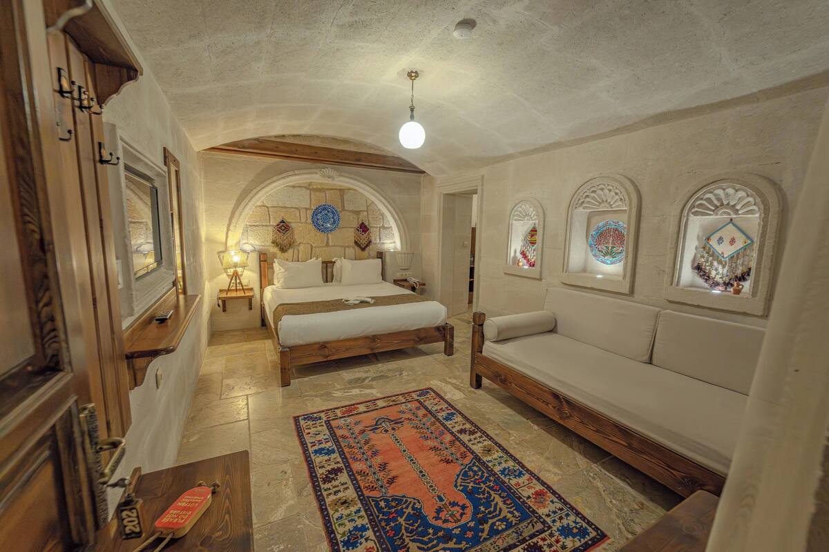 Une chambre à coucher avec un lit, un canapé, une table en bois et un tapis.