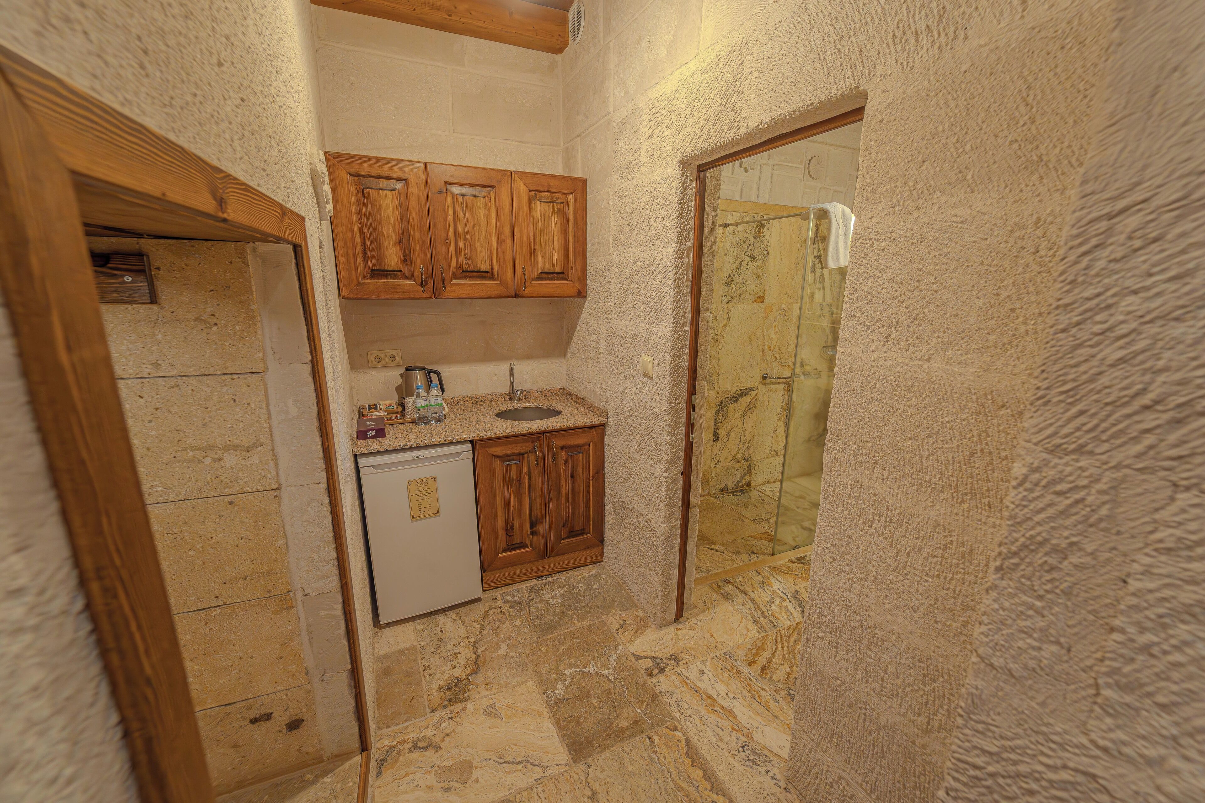 A compact kitchen with wooden cabinets, a sink, and a dishwasher.