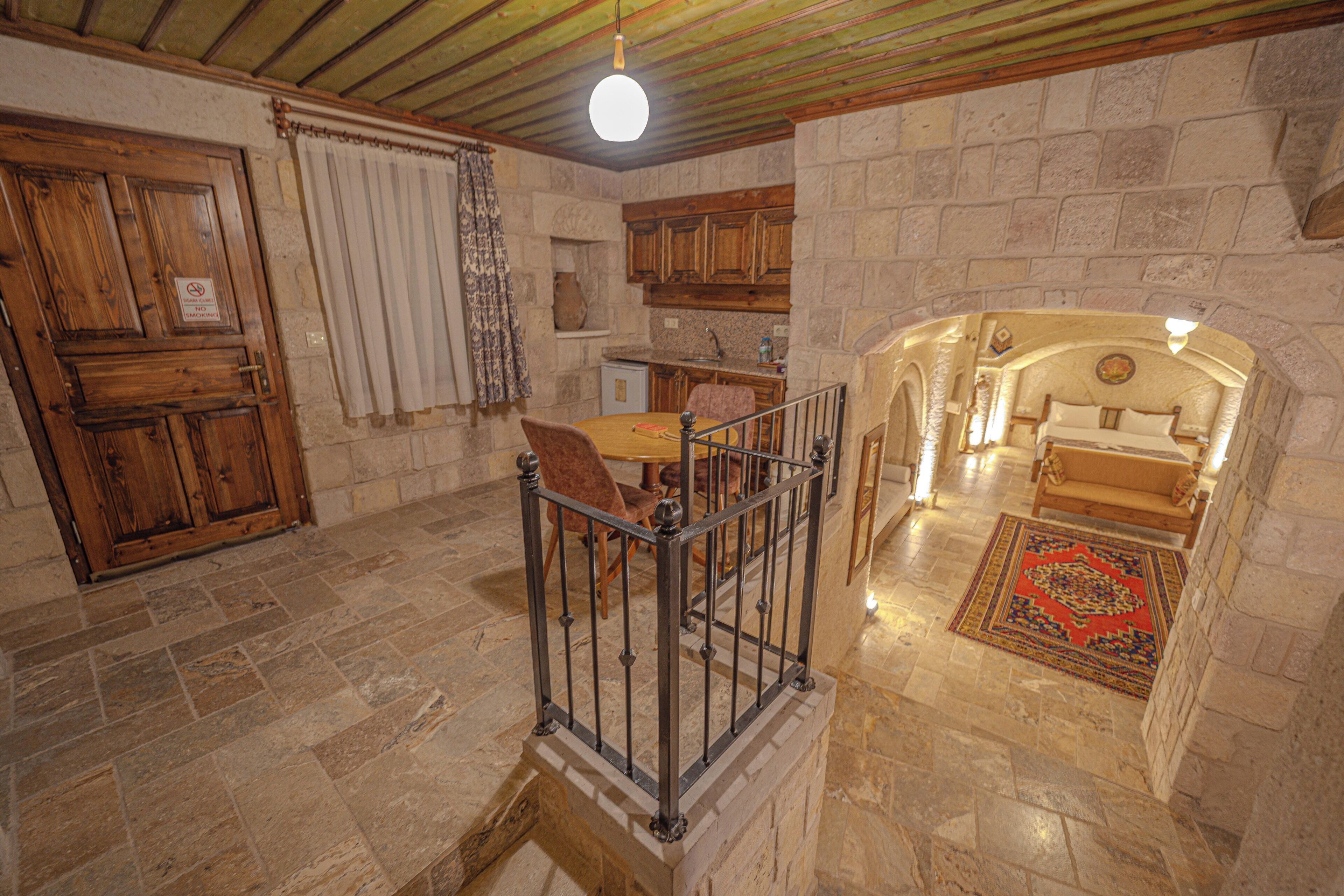 Un interior rústico con paredes de piedra, muebles de madera y suelo de piedra.