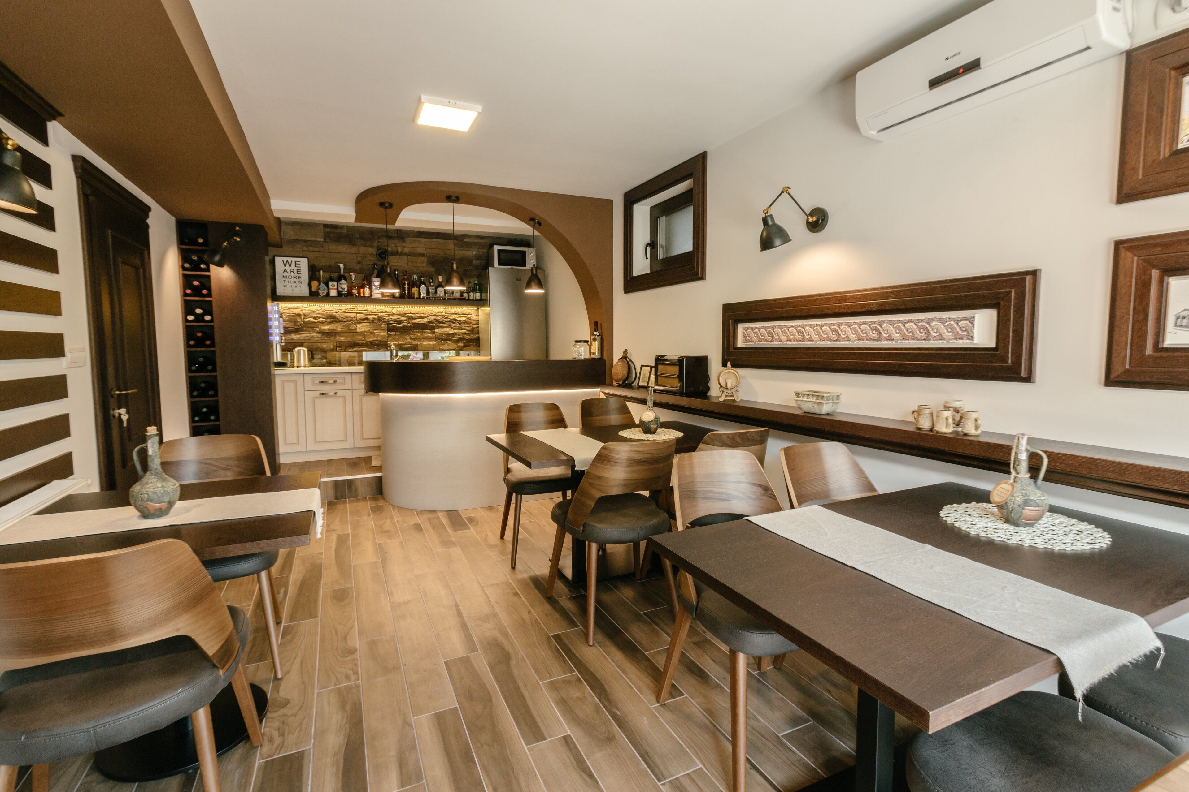 Een moderne eetruimte met houten meubels, een bar op de achtergrond en een stenen muur.