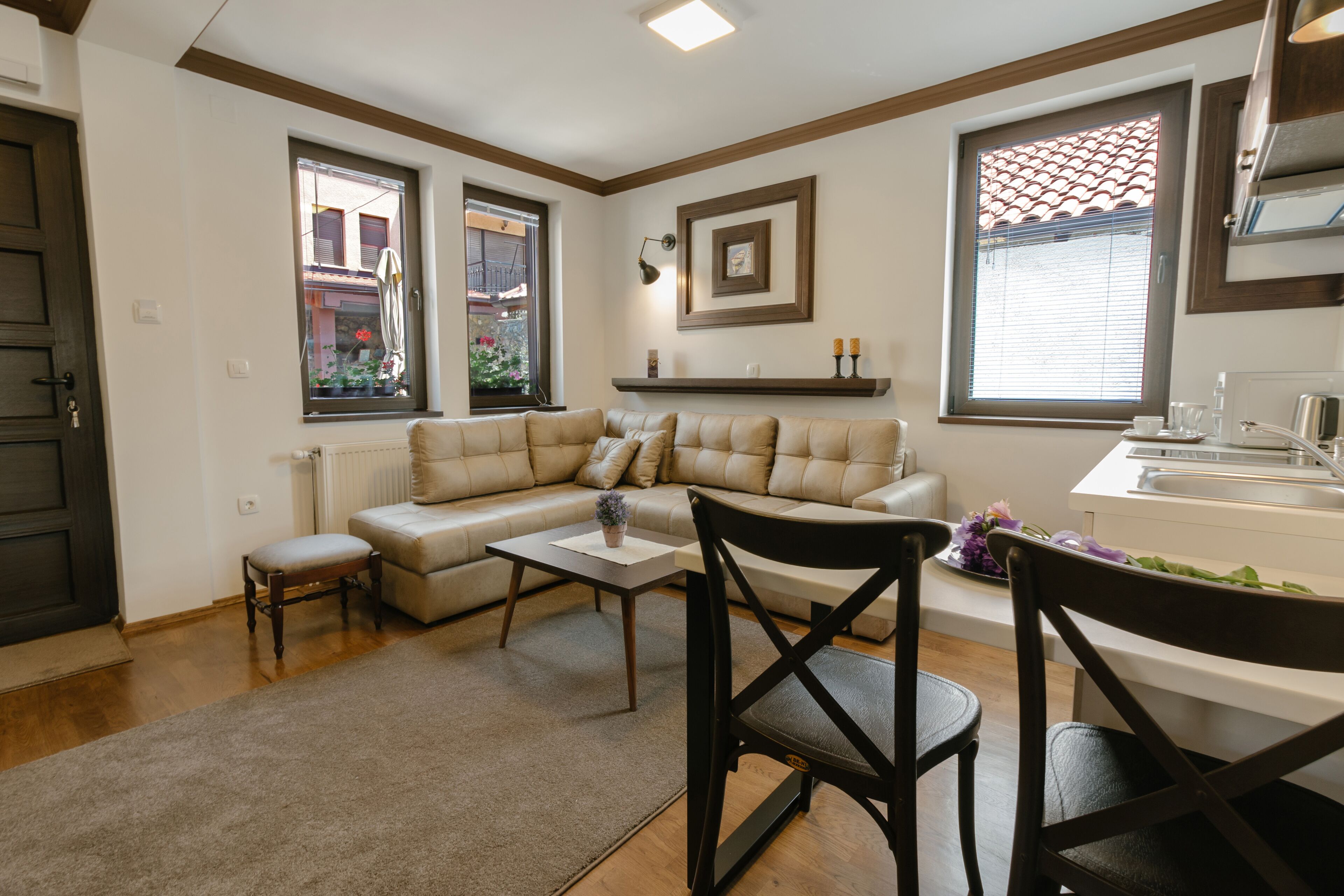 Una sala moderna con un sofá modular, una mesa de comedor y una zona de cocina.