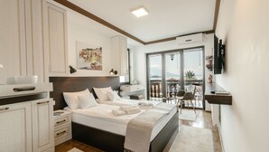 Un dormitorio moderno con una cama grande, mesitas de noche, un escritorio y un balcón con vistas.