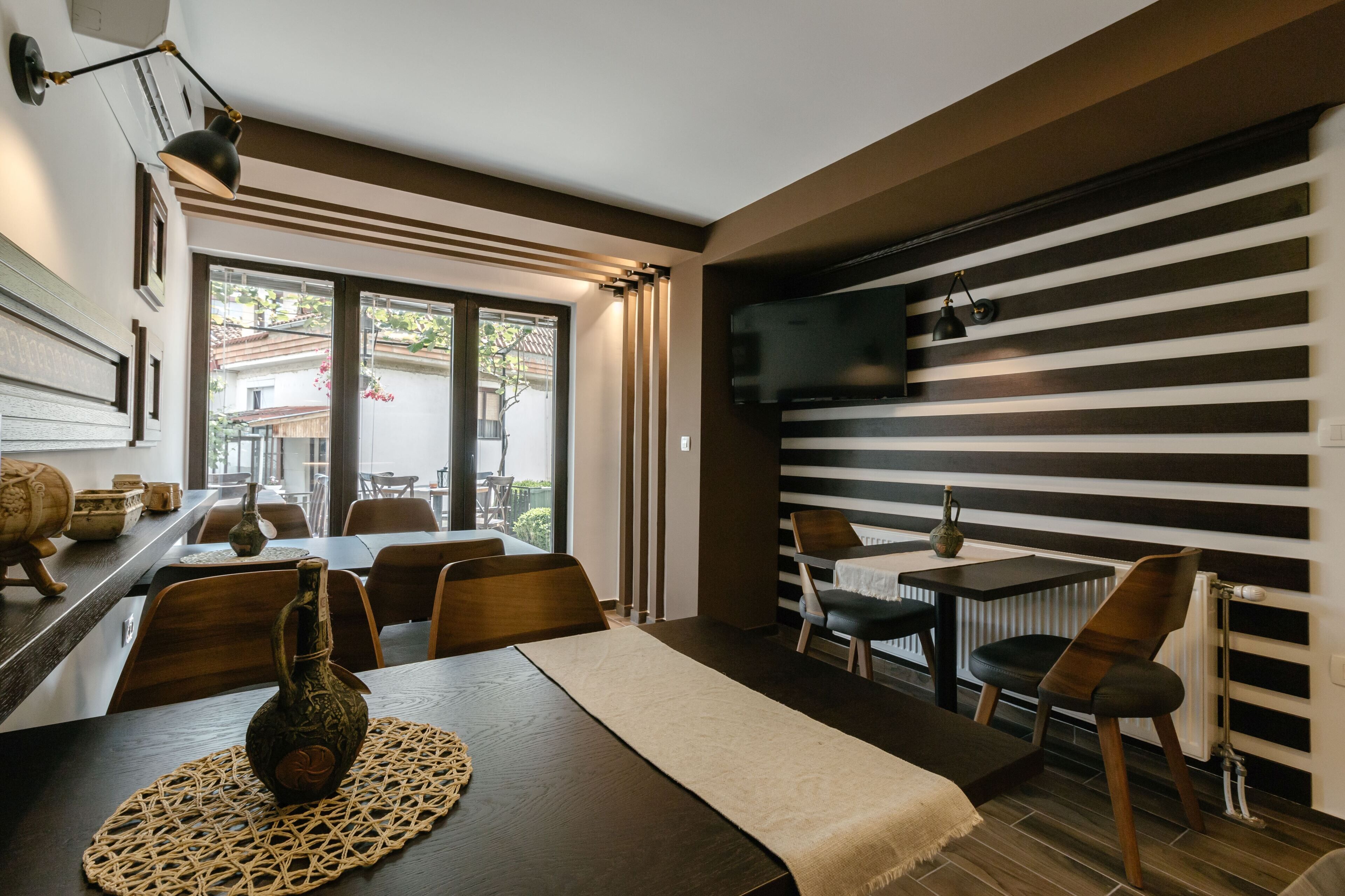 A dining area with a long table, chairs, a woven placemat, and a decorative vase.