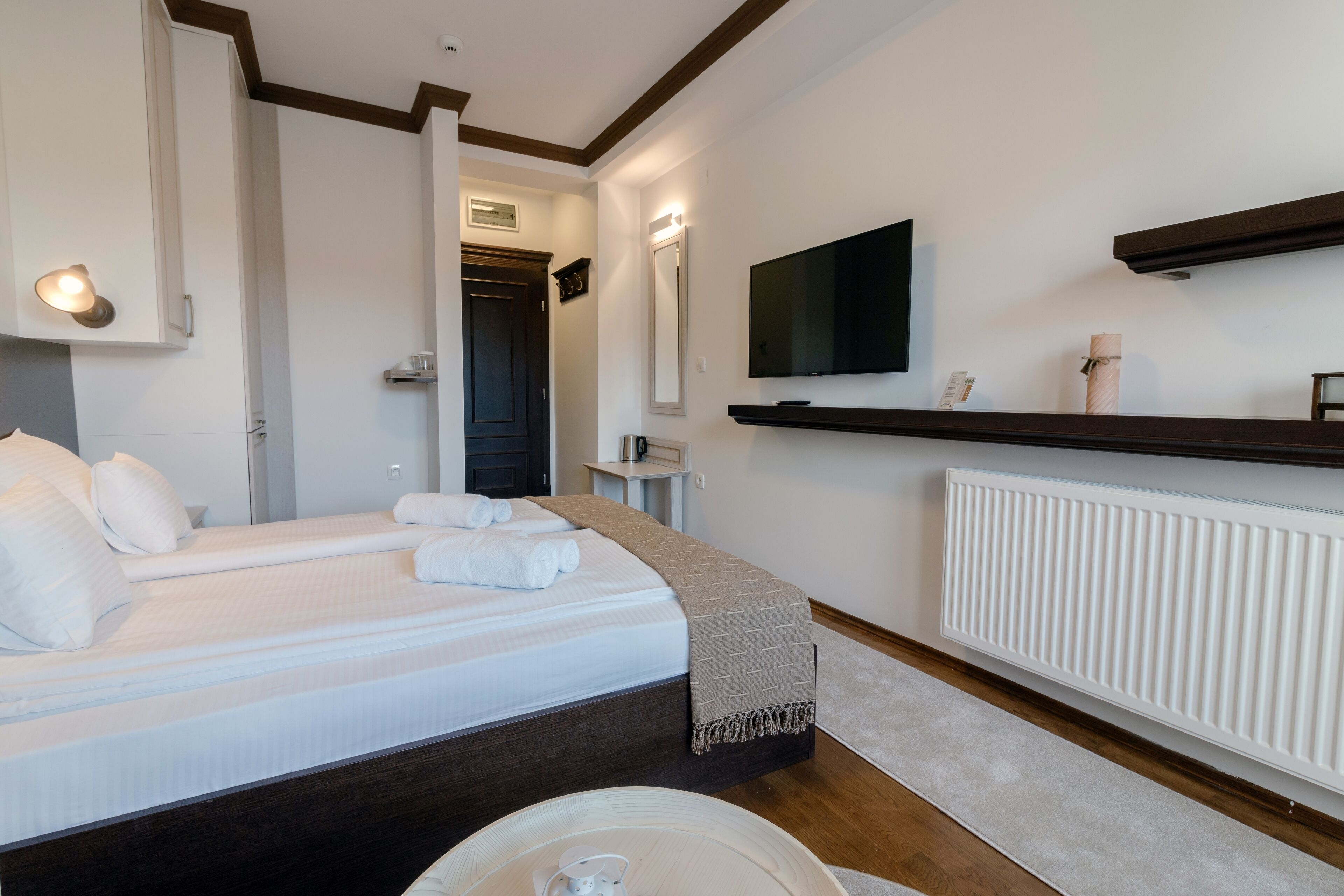 Habitación de hotel con una cama grande, un televisor montado en la pared y un calentador integrado.