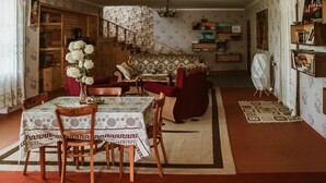 Un comedor con una mesa lista para dos personas, un sofá y una escalera que lleva a un nivel superior.