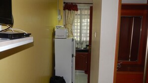 Une cuisine compacte équipée d’un réfrigérateur, d’un four à micro-ondes et d’un petit plan de travail.