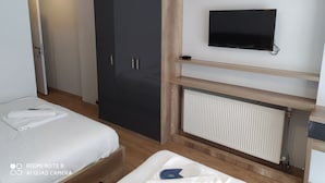 A modern hotel room with a bed, a wardrobe, a television, and a radiator. - Akdeniz Van Otel (Van)