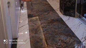 A modern hotel lobby with a marble floor, a seating area, and an elevator. - Akdeniz Van Otel (Van)