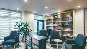 A lobby with a reception desk, seating area, and a bookshelf with various items. - Hotel Kuretakeso Kyoto Kiyomizu Gojo (Kyoto)
