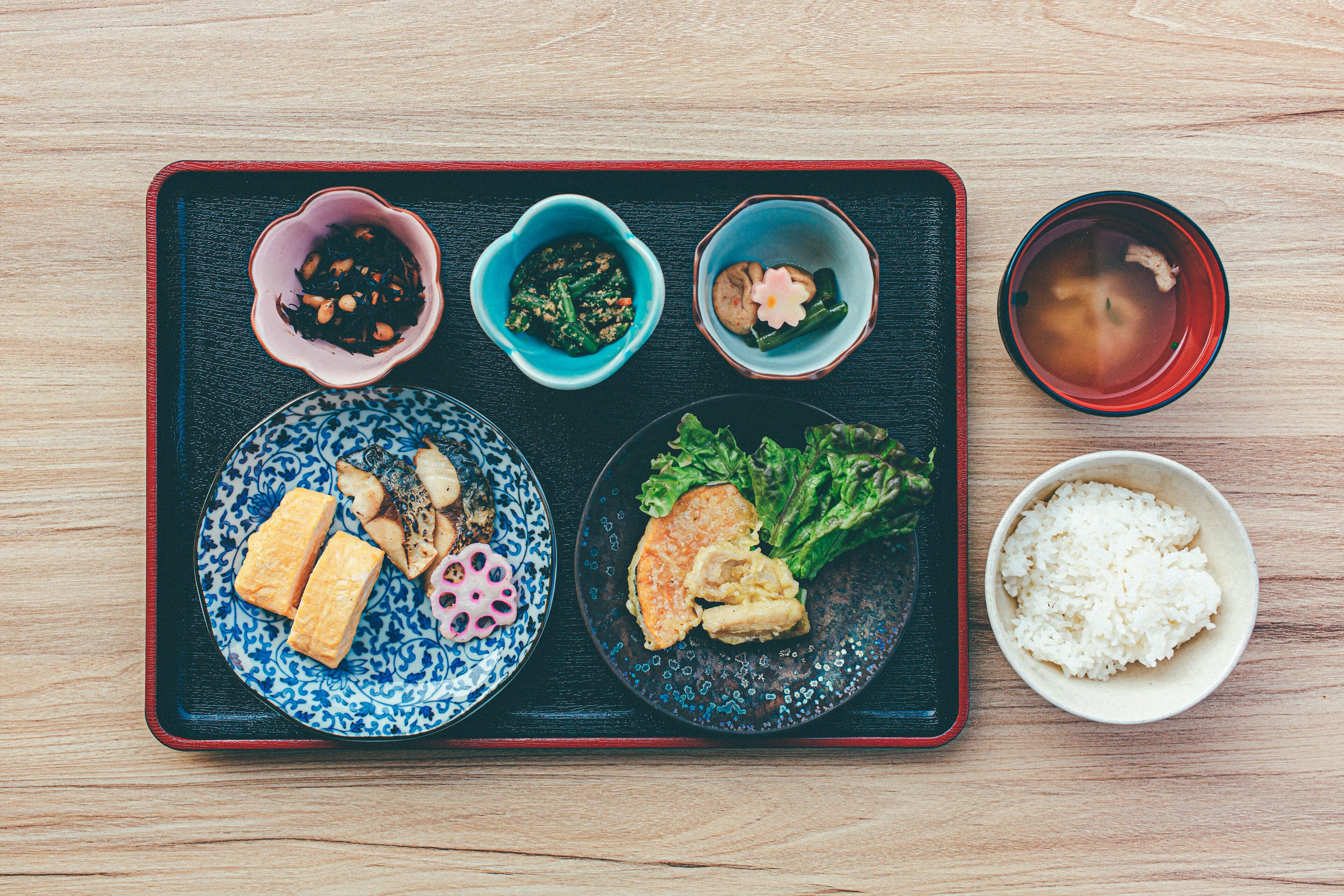 A tray with various dishes including tofu, rice, and vegetables.