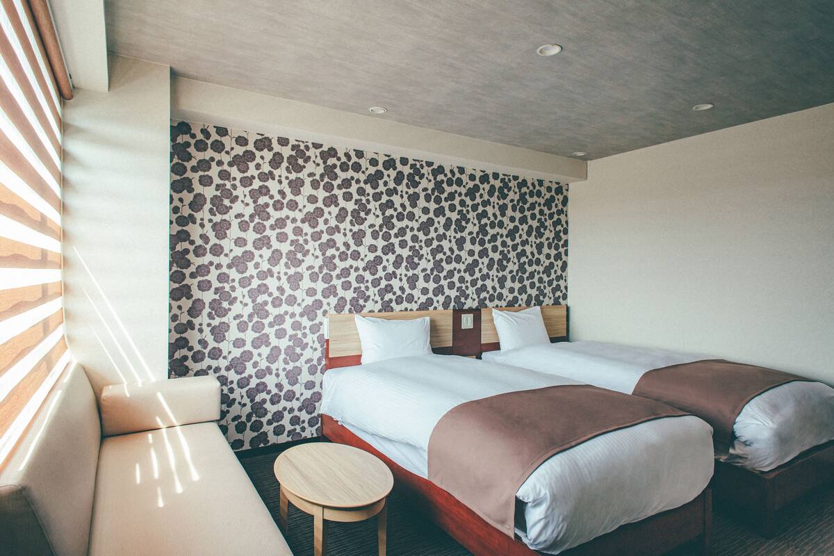 Une chambre d’hôtel avec un lit double, une petite table ronde et un canapé.