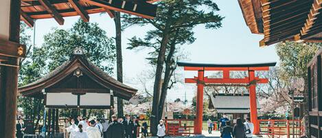 A traditional Japanese gate with a red torii, surrounded by visitors.