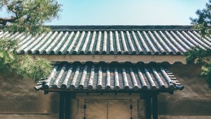 A traditional building with a tiled roof and a wooden door with a circular emblem. - Hotel Kuretakeso Kyoto Kiyomizu Gojo (Kyoto)