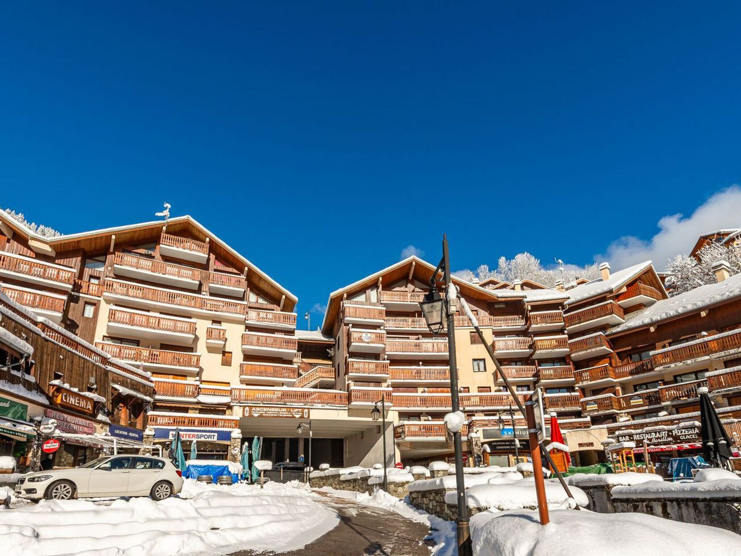A multi-story hotel with balconies, a cinema, and a restaurant.