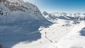 A snow-covered mountain landscape with ski slopes and a ski lift.