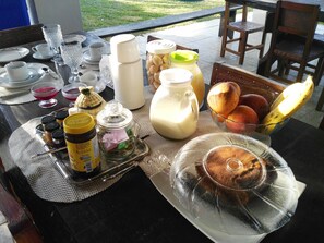 A breakfast table with various food items, condiments, and utensils.