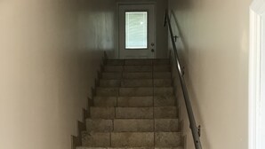 A staircase with a metal handrail leading to a door with a window. - TAMPA FLORIDA VACATION DELIGHT (Tampa)
