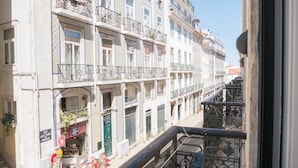 A multi-story building with balconies, a ground-level shop, and a staircase leading to an upper floor. - No Limit Alfama Guesthouse (Lisbon)