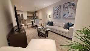 A modern living room with a sofa, coffee table, and dining area.