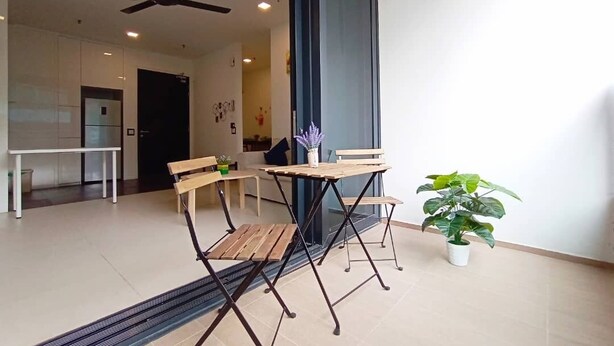 A modern living area with a foldable wooden table and chairs, a ceiling fan, and a potted plant.