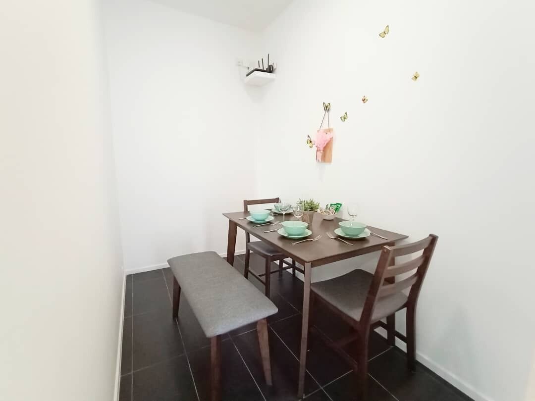 Uma área de refeições com mesa de madeira preparada para quatro pessoas, incluindo um banco.
