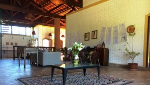 Un hall d’entrée spacieux agrémenté d’un tapis à motifs, d’une table basse, d’un coin salon et d’œuvres d’art accrochées aux murs.
