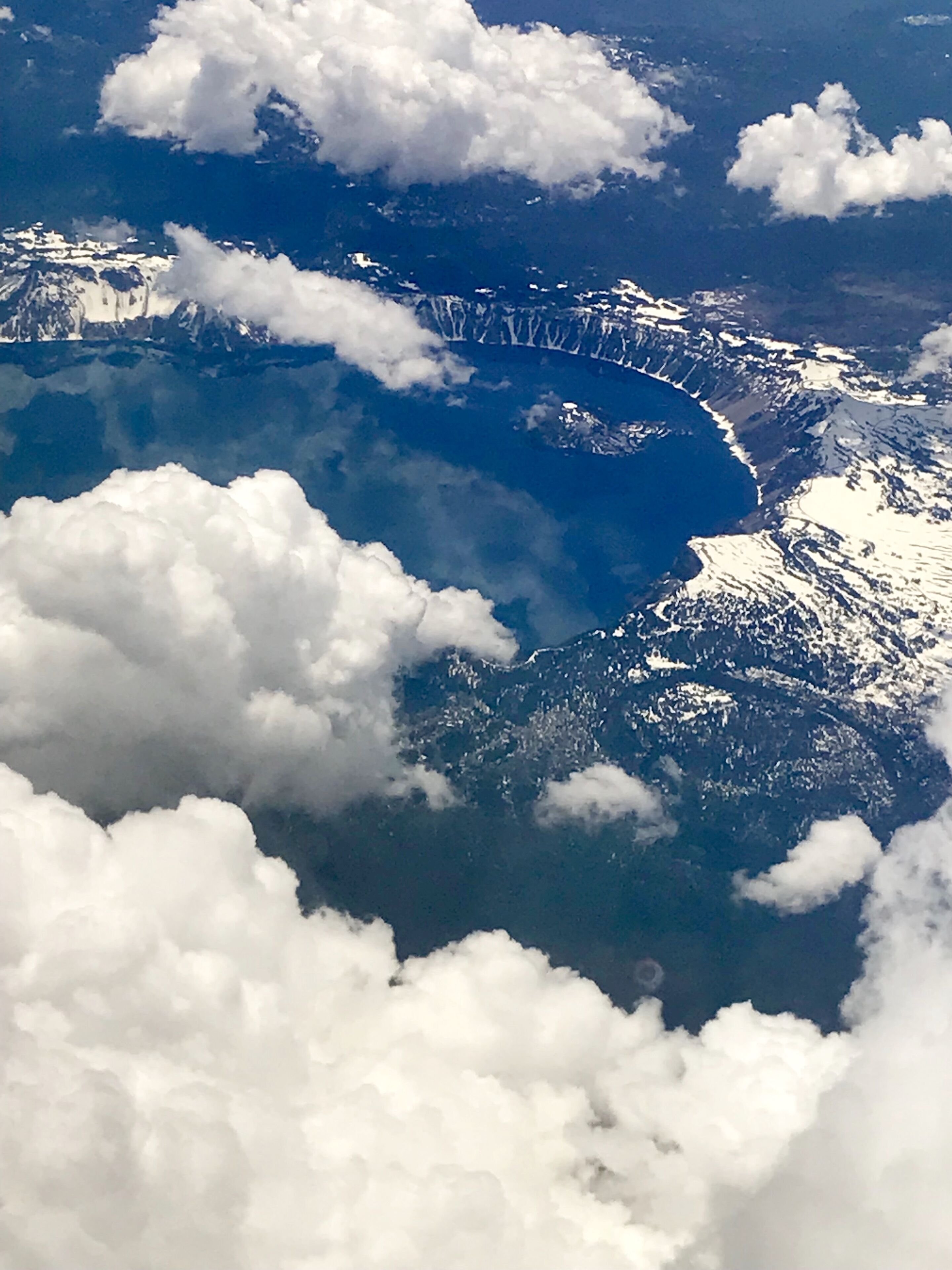 Une vue sur un paysage montagneux avec un plan d’eau et des sommets enneigés.