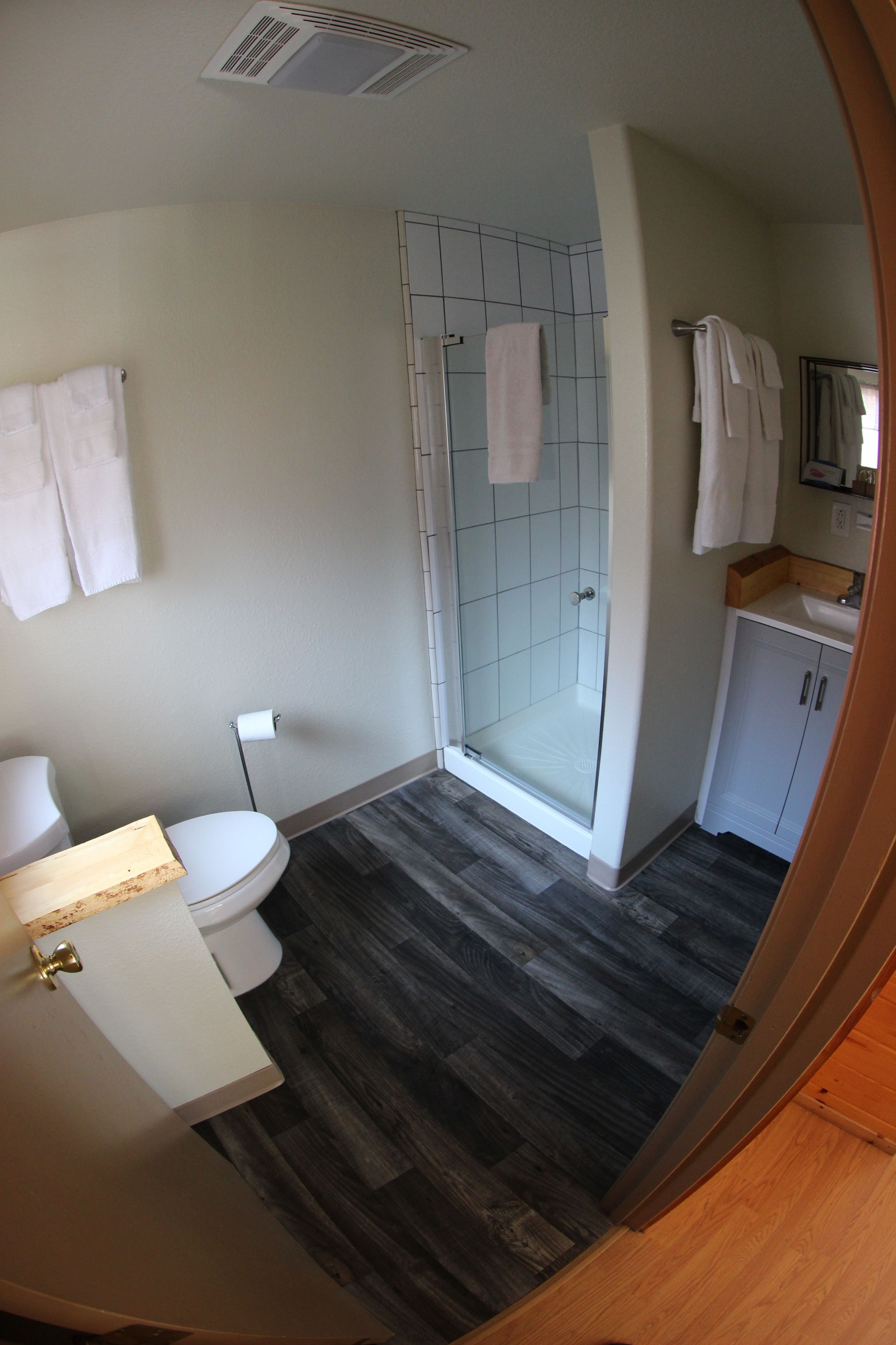 Un baño con inodoro, lavamanos y zona de ducha.