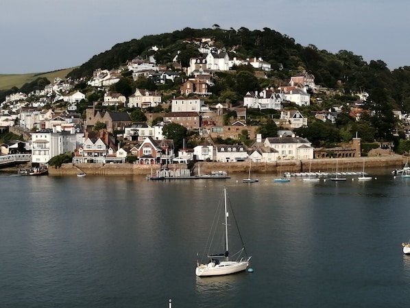 Explore a picturesque coastal town with a harbor, residential buildings, and a scenic bridge.