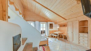 A wooden interior with a staircase, a dining area, and a kitchen. - Cosy Apartment "Seekaralm" with Balcony, Garden & Wi-Fi (Lenggries)