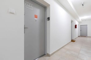 A hallway with a door labeled "046" and a fire extinguisher mounted on the wall.