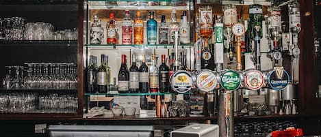 Een bar met verschillende drankflessen en een tappinstallatie.