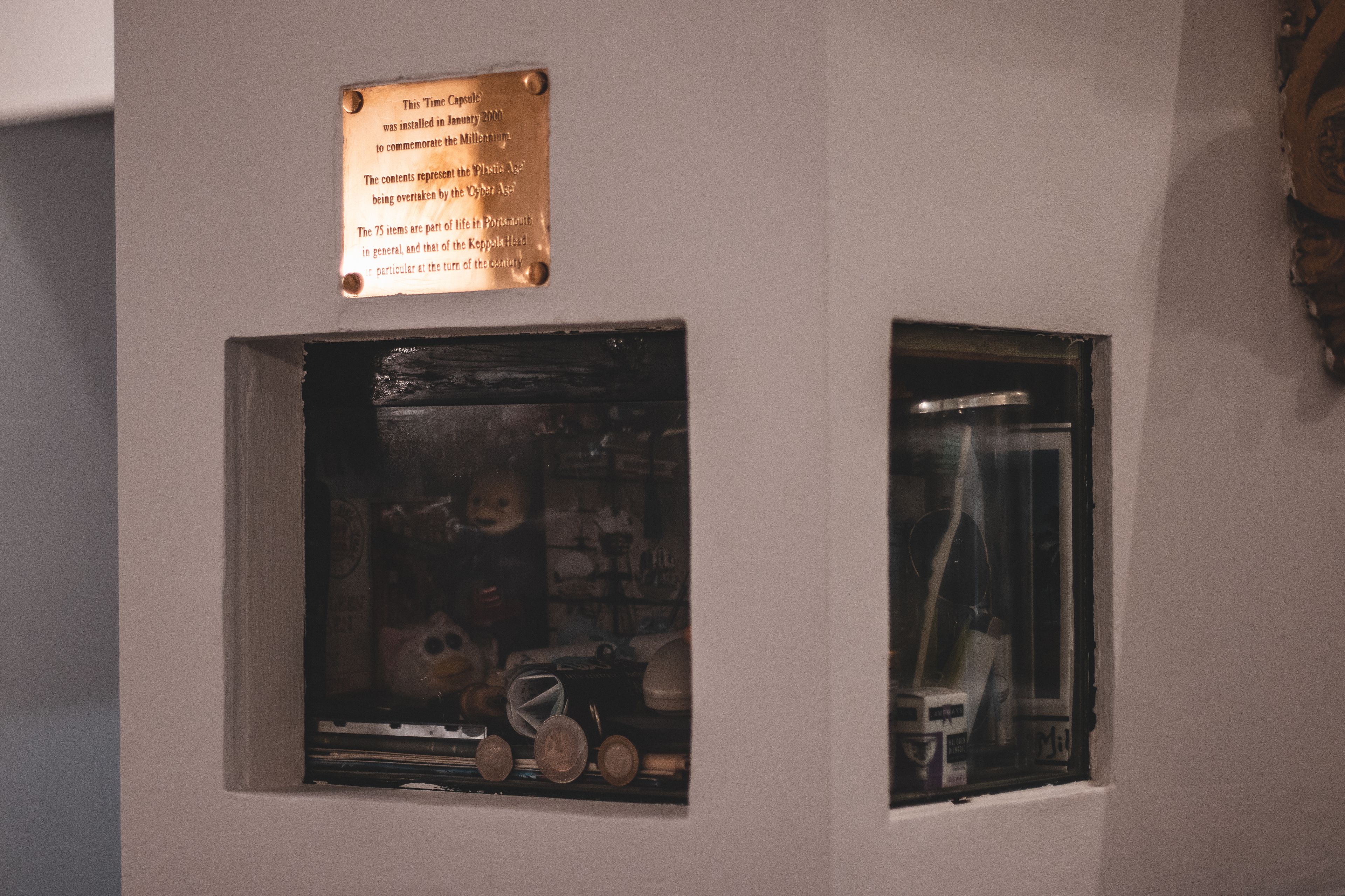 A plaque commemorating the Millennium, a display case with various items, and a window with a view.