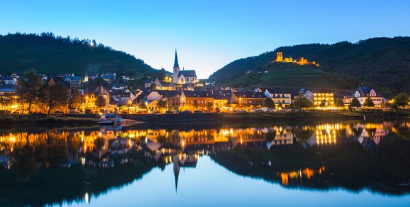A town with a prominent church and castle on a hill, reflecting in a calm river. - Relaxing, modern apartment in a sunny location (Klotten)