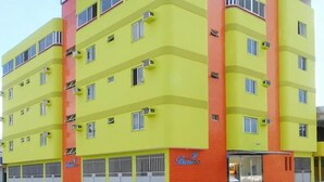 A multi-story hotel with a bright yellow facade and red accents. - Hotel Beira Rio (Itabuna)