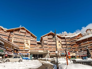 A ski resort with multi-story wooden buildings, a cinema, and a restaurant.