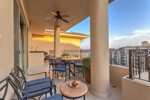 A balcony with a table, chairs, a ceiling fan, and a potted plant. - Top Floor! Medano Beachfront! Walkable to Marina and Downtown Cabo! (Cabo San Lucas)