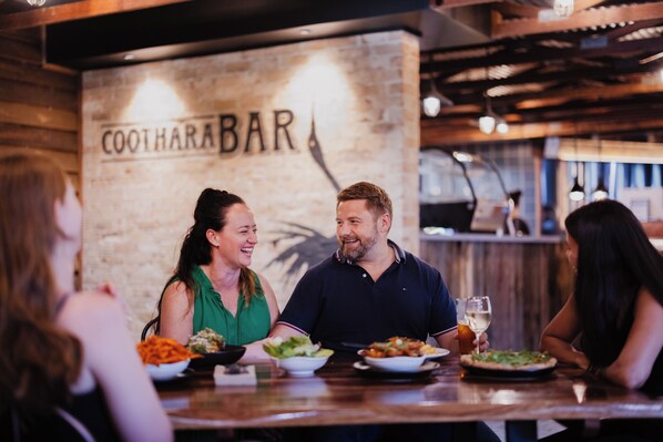 Interior de un restaurante con una pared de madera y un cartel que dice "COOTHARA BAR".