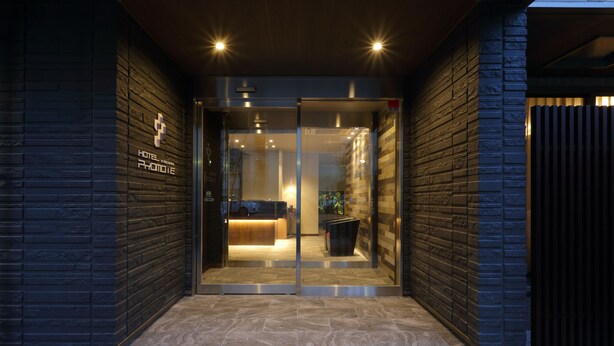 A hotel entrance with a glass door, a reception desk, and a sign indicating the hotel name. - Hotel Promote Hiroshima (Hiroshima)