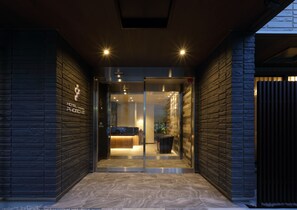 A hotel entrance with a glass door, a reception desk, and a sign indicating the hotel name. - Hotel Promote Hiroshima (Hiroshima)