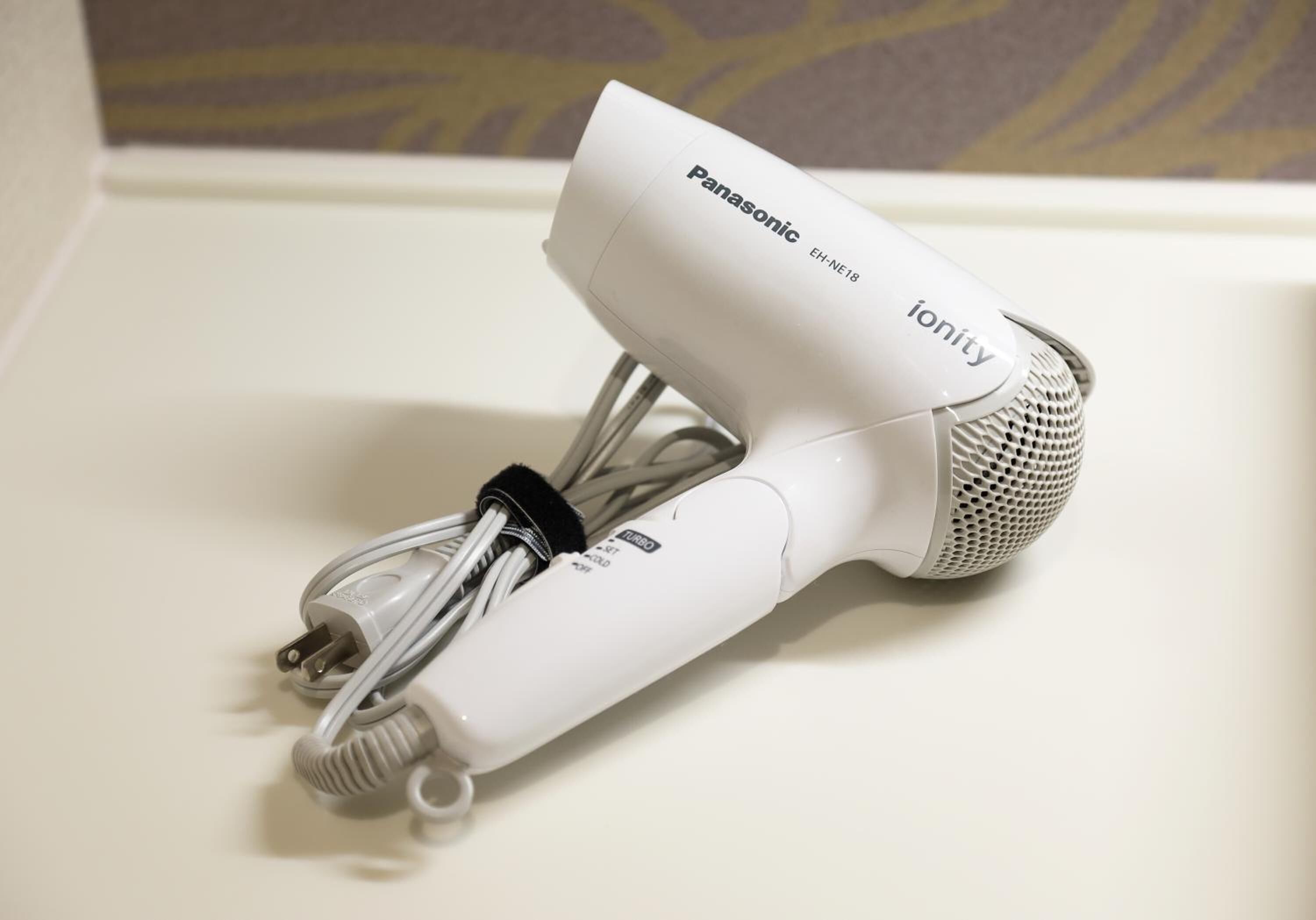 Een Panasonic ionity haardroger met een snoer op een wit oppervlak.