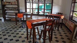 A room with a checkered floor, wooden furniture, and a window with a view. - Mitos Hostal (Intibucá)