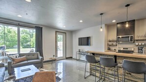 Een moderne keuken met een bar, een flatscreen-tv en een groot raam met uitzicht op de omgeving.