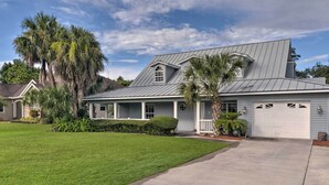 A single-story house with a grey metal roof, a front porch, and a garage. - Waterfront Lake Placid Home w/ Dock & Fire Pit (Lake Placid)
