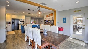 A spacious kitchen with modern appliances, a dining area with a wooden table and chairs, and a cozy seating area with a red bucket. - Waterfront Lake Placid Home w/ Dock & Fire Pit (Lake Placid)