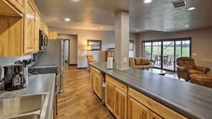 A modern kitchen with wooden cabinets, stainless steel appliances, and a large island. - Black Hills Retreat ~ 3 Mi to ATV Trails! (Piedmont)