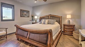 A bedroom with a large bed, a ceiling fan, a nightstand with a lamp, and a window with a view. - Black Hills Retreat ~ 3 Mi to ATV Trails! (Piedmont)