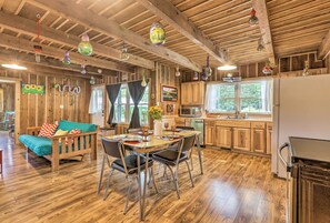 Una cocina amplia con armarios de madera, un comedor con mesa y sillas, y una sala de estar acogedora con sofá.