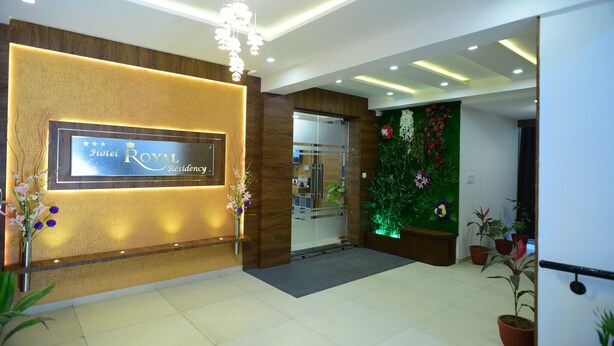 A hotel reception area with a modern design, a reception desk, and a wall-mounted sign that reads "Hotel Royal Residency". - Hotel Royal Residency (Vadodara)
